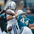 Indianapolis Colts quarterback Joe Flacco (15) fumbles as he is hit by Jacksonville Jaguars' Travon Walker (44) during the first half of an NFL football game, Sunday, Oct. 6, 2024, in Jacksonville, Fla. (AP Photo/John Raoux)