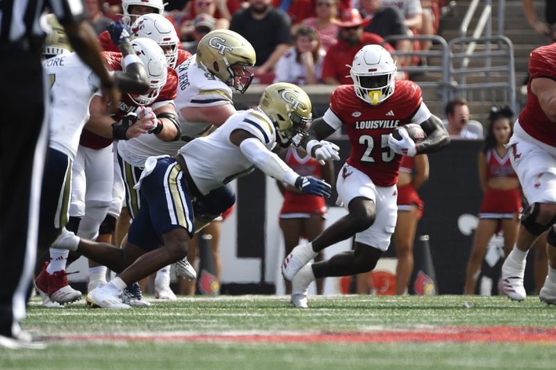 Louisville running back Isaac Brown (25) attempts to avoid the tackle attempt of Georgia Tech linebacker Trenilyas Tatum (0) during the first half of an NCAA college football game in Louisville, Ky., Saturday, Sept. 21, 2024. (AP Photo/Timothy D. Easley)