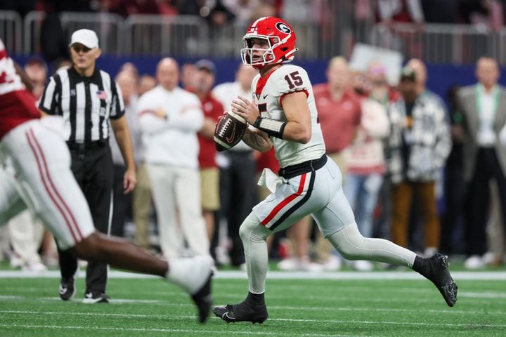 Georgia Bulldogs quarterback Carson Beck (15) scrambles against the Alabama Crimson Tide during the first half of the SEC Championship football game at the Mercedes-Benz Stadium in Atlanta, on Saturday, December 2, 2023. (Jason Getz / Jason.Getz@ajc.com)