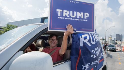 A pro-Trump protester holds a sign at a July 30 Kamala Harris speech at the Georgia State Convention Center in Atlanta. (Ziyu Julian Zhu/The Atlanta Journal-Constitution)