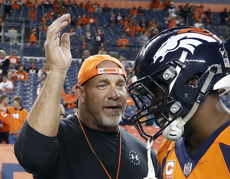 FILE - In this Sept. 11, 2017, file photo, professional wrestler Bill Goldberg, left, greets Denver Broncos outside linebacker Von Miller prior to an NFL football game against the Los Angeles Chargers in Denver. (AP Photo/Jack Dempsey, File)