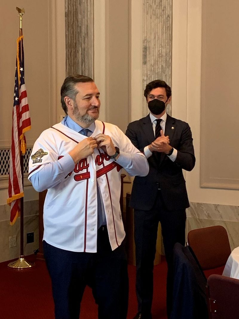 U.S. Sen. Jon Ossoff presents a Fred McGriff jersey to U.S. Sen. Ted Cruz after the Texas Republican lost a World Series bet.