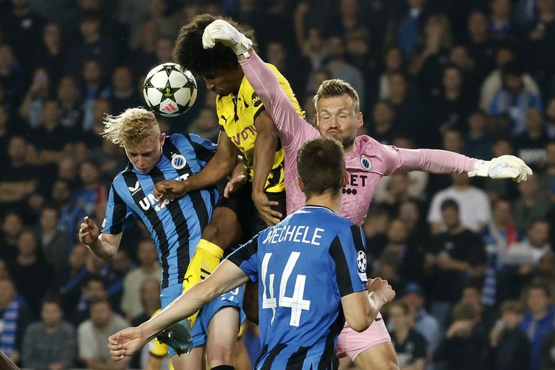 Brugge's Joaquin Seys, Dortmund's Karim Adeyemi and Brugge's goalkeeper Simon Mignolet, from left, challenge for the ball during the Champions League opening phase soccer match between Club Brugge and Borussia Dortmund at Jan Breydelstadion in Bruges, Belgium, Wednesday, Sept. 18, 2024. (AP Photo/Omar Havana)