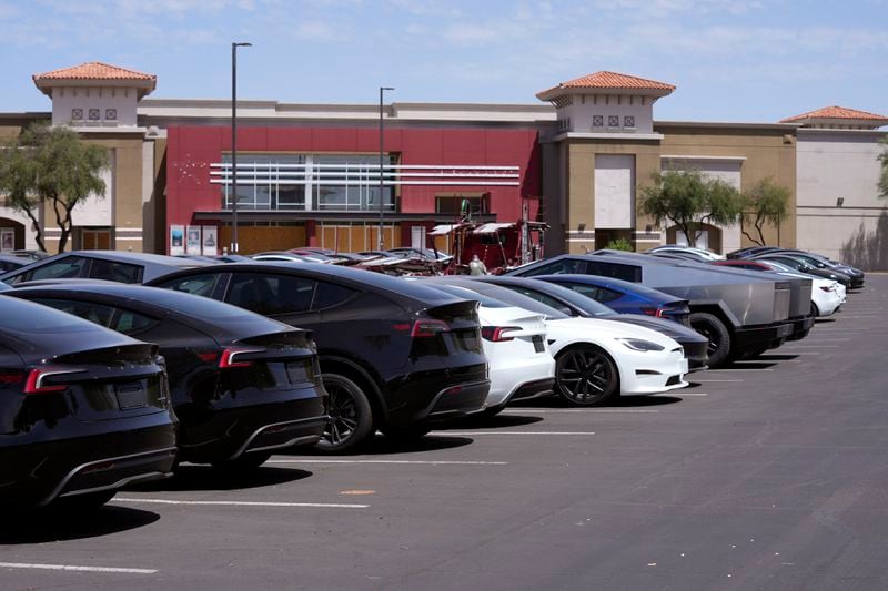 Tesla vehicles are stored at a shopping mall parking lot near a closed movie theater Friday, June 21, 2024, in Scottsdale, Ariz. (AP Photo/Ross D. Franklin)