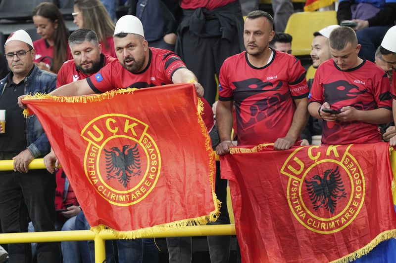 Albanian supporters hold flags of the Kosovo Liberation Army, also known as the UÇK, as they wait for the start of the Group B match between Italy and Albania at the Euro 2024 soccer tournament in Dortmund, Germany, Saturday, June 15, 2024. (AP Photo/Martin Meissner)