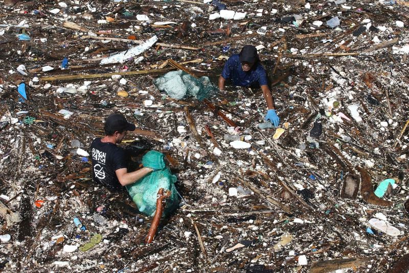 FILE - Volunteers pick up trash on a river in Pecatu, Bali, Indonesia, March 22, 2024. (AP Photo/Firdia Lisnawati, File)