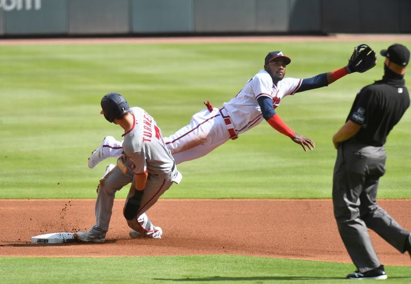 Washington shortstop Trea Turner (7) slides into second base safely as Braves second baseman Adeiny Hechavarria (24) is not able to catch the throwing error during the first inning in the first game of a day-night doubleheader Friday, Sept. 4, 2020, at Truist Park in Atlanta. (Hyosub Shin / Hyosub.Shin@ajc.com)