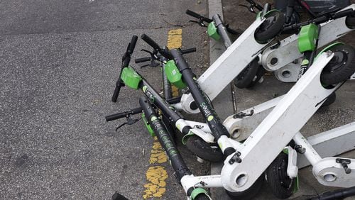 Sharable e-scooters lay knocked in a lane along Centennial Olympics Park Drive NW near Centennial Olympic Park Atlanta. (Alyssa Pointer/alyssa.pointer@ajc.com)