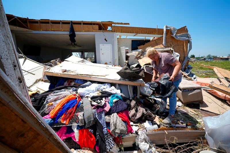Juana Landeros, who rode out deadly tornado with her husband and her 9-year-old son when it rolled through the previous night, salvages items from her destroyed home, Sunday, May 26, 2024, in Valley View, Texas. Powerful storms left a wide trail of destruction Sunday across Texas, Oklahoma and Arkansas after obliterating homes and destroying a truck stop where drivers took shelter during the latest deadly weather to strike the central U.S. (AP Photo/Julio Cortez)