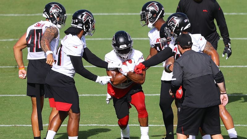 Running the gauntlet: Ito Smith works during a ballhandling drill while Keith Smith (from left), Todd Gurley, Brian Hill, Delrick Abrams and Mikey Daniel defend during training camp practice in Flowery Branch. (Curtis Compton/ccompton@ajc.com)