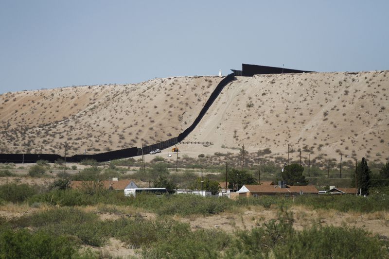 Border Patrol vehicles survey a steel fence at the Southwest border with Mexico at Sunland Park, N.M., Thursday, Aug. 22, 2024. The politics of immigration look different from communities on the Southwest border that are voting in hotly contested congressional races. (AP Photo/Morgan Lee)