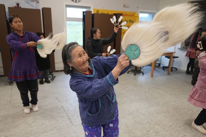 Marie Carl, 75, performs during an Indigenous drum and dance in Mertarvik, Alaska on Thursday, Aug. 15, 2024. (AP Photo/Rick Bowmer)