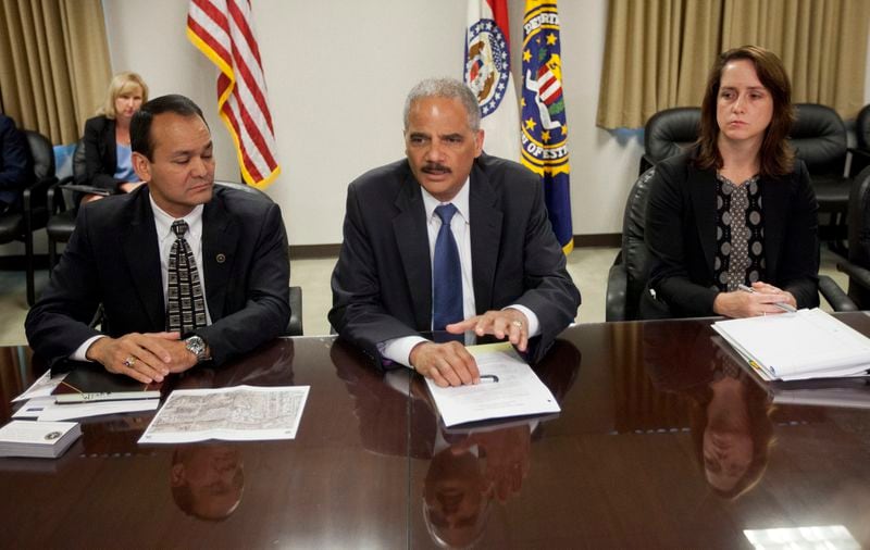 FILE - Attorney General Eric Holder, center, meets with Special Agent in Charge William P. Woods, left, and Acting Assistant Attorney General for Civil Rights Molly Moran at the FBI building in St. Louis, Wednesday, Aug. 20, 2014. Holder arrived in Missouri following the fatal shooting by a Ferguson, Mo., police officer of 18-year-old Michael Brown. (AP Photo/Pablo Martinez Monsivais, Pool, File)