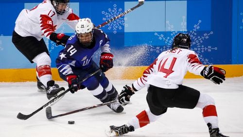 FILE - Brianna Decker (14), of the United States, skates with the puck away from Bailey Bram (17) and Renata Fast (14), of Canada, during the first period of the women's gold medal hockey game at the 2018 Winter Olympics in Gangneung, South Korea, Thursday, Feb. 22, 2018. (AP Photo/Jae C. Hong, File)