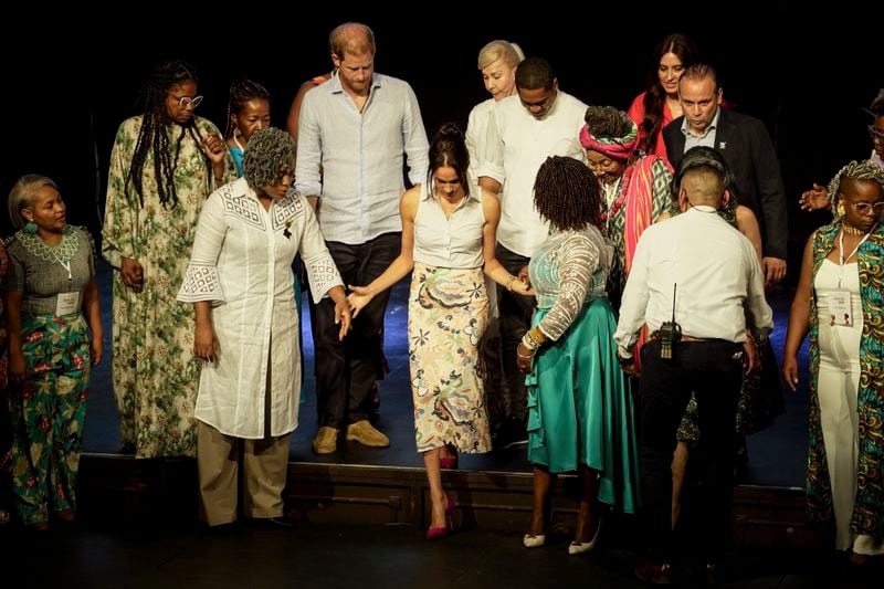 Prince Harry and his wife Meghan get ready for a group photo after a forum on Afro women and power in Cali, Colombia, Sunday, Aug. 18, 2024. (AP Photo/Ivan Valencia)