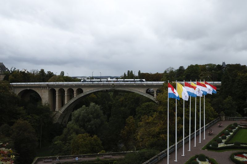 A tramway crosses the iconic Adolphe Bridge where flags of the Vatican and Luxembourg are seen waving in the surrounding gardens on the day before Pope Francis' trip to Luxembourg and Belgium, Wednesday, Sept. 25, 2024, (AP Photo/Omar Havana)