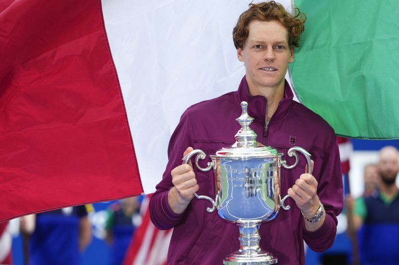 Jannik Sinner, of Italy, holds up the championship trophy after defeating Taylor Fritz, of the United States, in the men's singles final of the U.S. Open tennis championships, Sunday, Sept. 8, 2024, in New York. (AP Photo/Kirsty Wigglesworth)