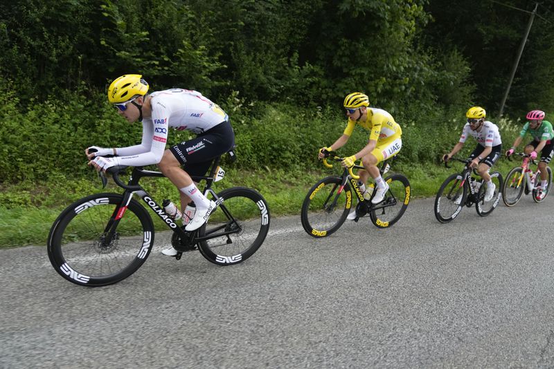 Slovenia's Tadej Pogacar, wearing the overall leader's yellow jersey, follows teammate France's Pavel Sivakov, with teammate Britain's Adam Yates in third position and Italy's Alberto Bettiol in fourth position during the fifth stage of the Tour de France cycling race over 177.4 kilometers (110.2 miles) with start in Saint-Jean-de-Maurienne and finish in Saint-Vulbas, France, Wednesday, July 3, 2024. (AP Photo/Jerome Delay)
