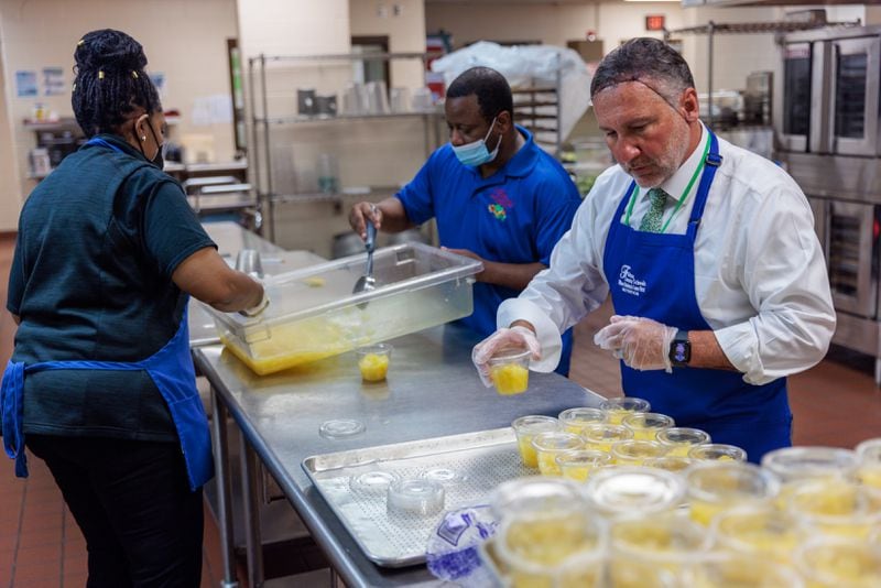 Fulton County Schools Superintendent Mike Looney (right) volunteers with the kitchen staff on the first day of school last year at Sandy Springs Charter Middle School in Sandy Springs on Monday, Aug. 8, 2022. (Arvin Temkar / arvin.temkar@ajc.com)