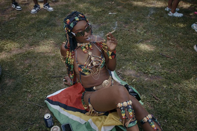 A reveler smokes during the West Indian Day Parade on Monday, Sept. 2, 2024, in the Brooklyn borough of New York. (AP Photo/Andres Kudacki)