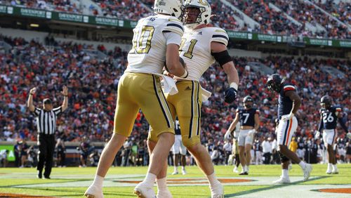 Georgia Tech quarterback Haynes King (10) celebrates with tight end Luke Benson (81) after scoring a touchdown during the first half of an NCAA college football game Saturday, Nov. 4, 2023, in Charlottesville, Va. (AP Photo/Mike Caudill)