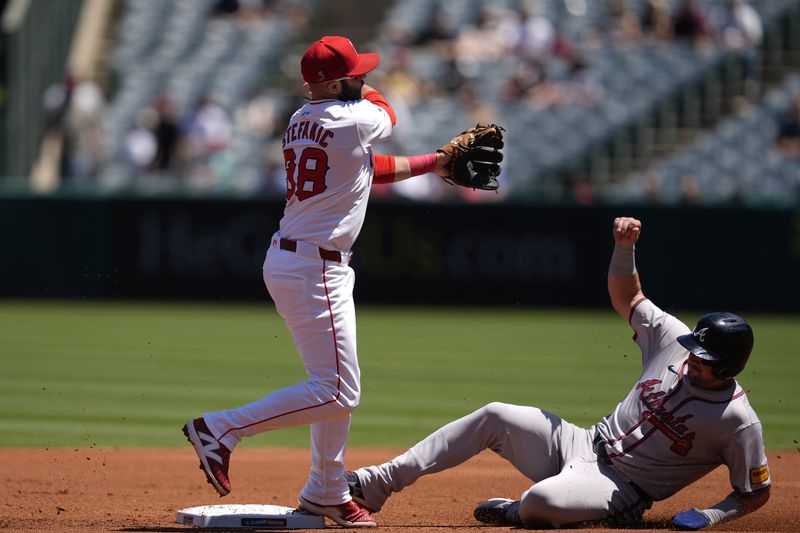 Los Angeles Angels second baseman Michael Stefanic, left, throws out Atlanta Braves designated hitter Marcell Ozuna at first base to complete a double play after forcing out Austin Riley, right, during the first inning of a baseball game, Sunday, Aug. 18, 2024, in Anaheim, Calif. (AP Photo/Ryan Sun)