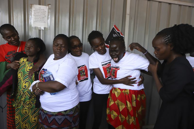 Relatives try to comfort a woman crying after viewing the body of Ugandan Olympic athlete Rebecca Cheptegei at Moi Teaching and Referral Hospital morgue in the western city of Eldoret, in Rift Valley, Kenya Friday, Sept. 13, 2024. (AP Photo/Andrew Kasuku)