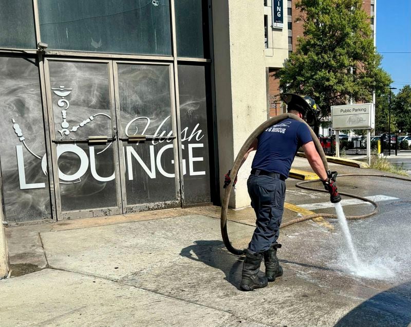 A firefighter cleans blood stains off the sidewalk outside a nightclub in Birmingham, Ala. on Sunday, Sept. 22, 2024, after a mass shooting took place. (AP Photo/Kim Chandler)