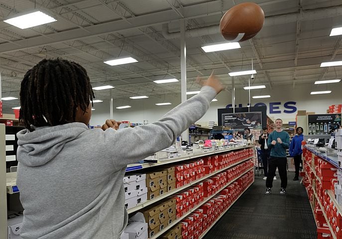 Ryan Little, 11,  throws a football to UGA quarterback Carson Beck during the Boys and Girls Club shopping spree at Academy. Carson Beck was on site at an Athens Academy store Sunday December 17, 2023, to give out gift cards to lucky members of area Boys and Girls Clubs. Academy contributed $200 for each child and he kicked in $135 more of his own money to help families out. 

credit: Nell Carroll for the AJC
