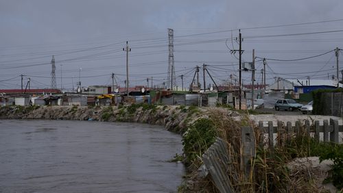 Water flows through Khayelitsha, Cape Town, South Africa, Thursday July 11, 2024. The South African city of Cape Town and surrounding areas have been hit by more storms, ripping roofs off houses and causing widespread flooding. (AP Photo/Nardus Engelbrecht)