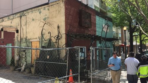 Pedestrians in downtown Decatur pass by Java Monkey, which closed in November due to a fire. The part of the property behind the fence used to feature the coffee shop’s wine bar and outdoor patio. That half of the business has since been torn down.