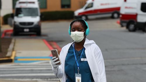 March 12, 2020 Kennesaw: A nurse wearing a mask and gloves for protection from the coronavirus walks past ambulances as she leaves Wellstar Kennestone on the afternoon that Georgia authorities confirmed the stateâs first coronavirus related death, a 67-year-old male hospitalized here on Thursday, March 12, 2020, in Kennesaw.   Curtis Compton ccompton@ajc.com