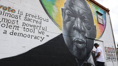 Kevin “Scene” Lewis touches up his mural of civil rights leader John Lewis on Monday, June 24, 2024, off of South Commercial Circle in Warner Robbins, Georgia. Lewis repainted parts of the mural after it was defaced. (Photo Courtesy of Katie Tucker/The Telegraph)