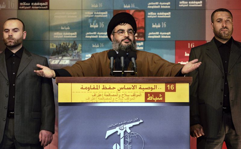 FILE - Hezbollah leader Hassan Nasrallah, flanked by two bodyguards, speaks to thousands of supporters in Beirut's southern suburbs, Friday, Feb. 16, 2007. (AP Photo/Ben Curtis, File)