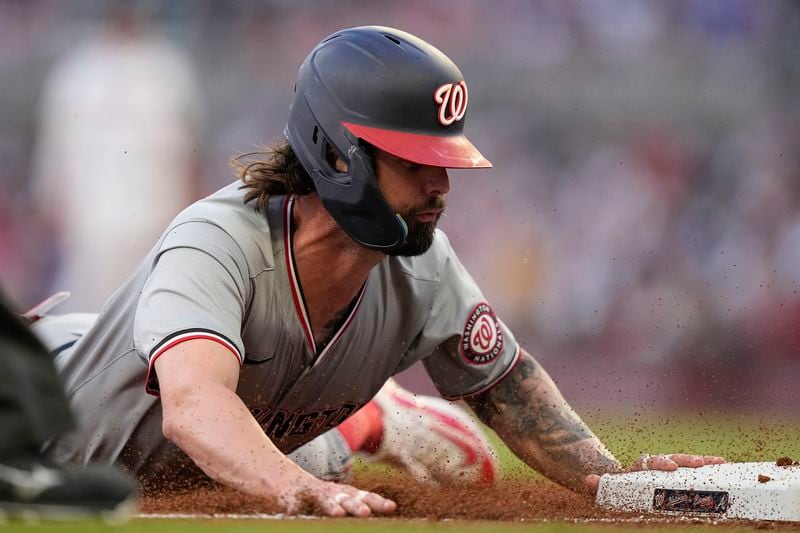 Washington Nationals' Jesse Winker (6) steals third base in the third inning of a baseball game against the Atlanta Braves, Thursday, May 30, 2024, in Atlanta. (AP Photo/Brynn Anderson)