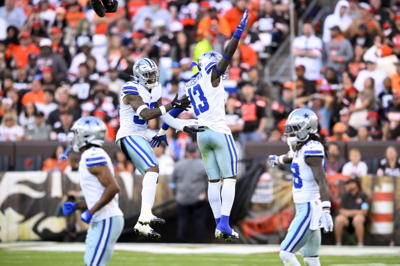 Dallas Cowboys' Juanyeh Thomas, center left, and DeMarvion Overshown (13) celebrate a stop against the Cleveland Browns in the second half of an NFL football game in Cleveland, Sunday, Sept. 8, 2024. (AP Photo/David Richard)