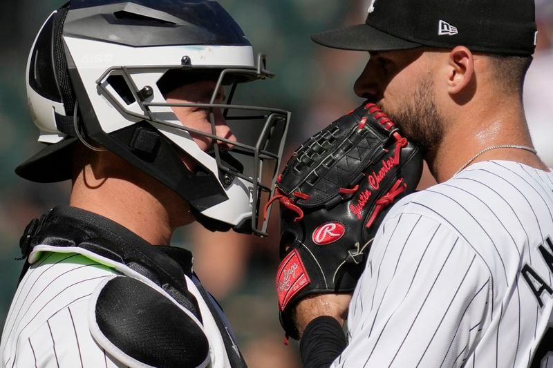 Chicago White Sox catcher Chuckie Robinson, left, talks with relief pitcher Justin Anderson, right, during the ninth inning of a baseball game against the New York Mets in Chicago, Sunday, Sept. 1, 2024. (AP Photo/Nam Y. Huh)