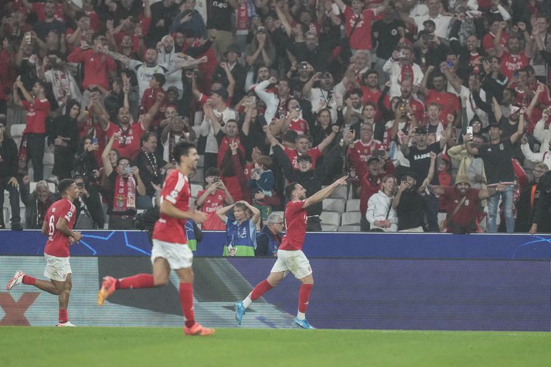 Benfica's Orkun Kokcu, right, celebrates after scoring his sides fourth goal during a Champions League opening phase soccer match between SL Benfica and Atletico Madrid in Lisbon, on Wednesday, Oct. 2, 2024.(AP Photo/Armando Franca)