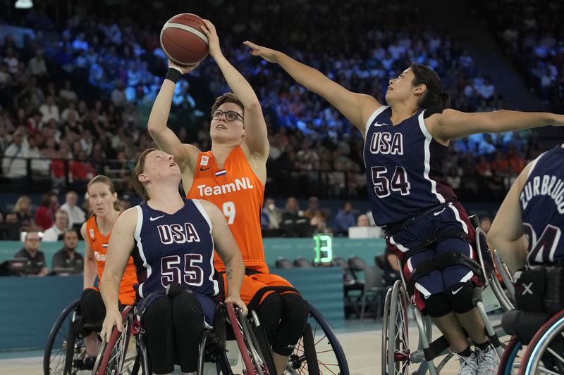 Bo Kramer of the Netherlands shoots while evading the defense of Isjelt Gonzalez of the United States during the gold medal match of the women's wheelchair basketball at the 2024 Paralympic Games between the Netherlands and the United States in Paris, France, Sunday, Sept. 8, 2024. (AP Photo/Christophe Haena)