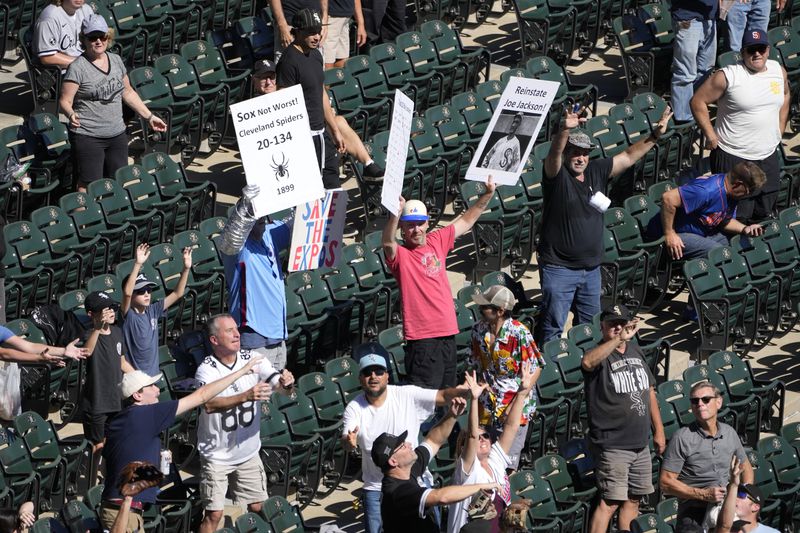 Chicago White Sox fans hold up signs as others try to catch T-shirts during a baseball game against the Los Angeles Angels,, Sept. 26, 2024, in Chicago. (AP Photo/Charles Rex Arbogast)