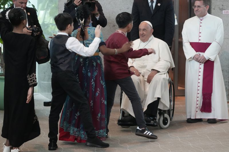 Pope Francis is welcomed by dancing children as he arrives at Singapore Changi International Airport, Wednesday, Sept. 11, 2024. Pope Francis is heading to Singapore for the final leg of his 11-day trip to Asia and Oceania. (AP Photo/Gregorio Borgia)