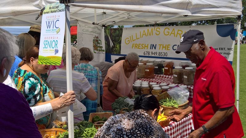 Seniors look over a selection of fresh fruits and vegetables at a local farmers market. In addition to Georgia Fresh for Less, low-income seniors can also get help buying fresh produce through the Senior Farmers Market Nutrition Program. Wholesome Wave Georgia doubles the value of the voucher so seniors can purchase more. CONTRIBUTED BY: Wholesome Wave Georgia.