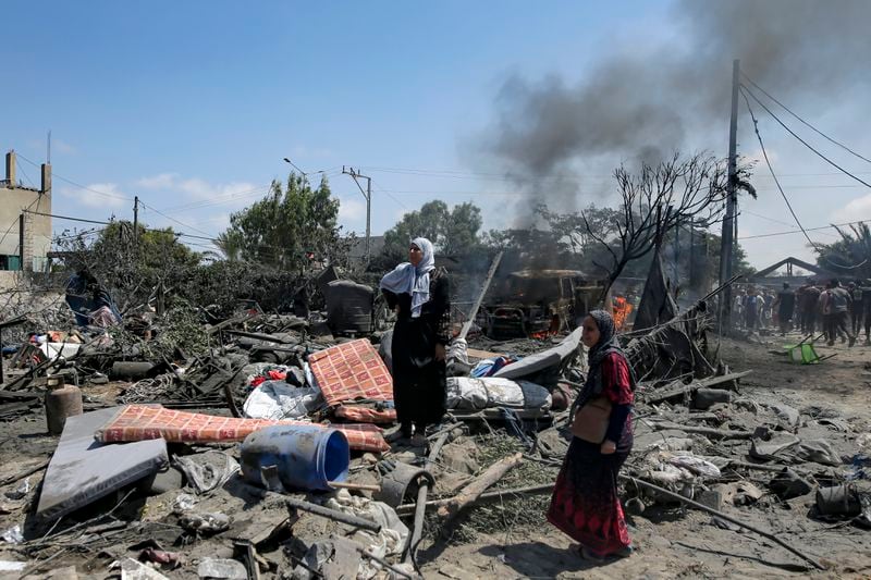 Palestinians inspect the damage at a site hit by an Israeli bombardment on Khan Younis, southern Gaza Strip, Saturday, July 13, 2024. Israel said it targeted Hamas' shadowy military commander in a massive strike Saturday in the crowded southern Gaza Strip that killed at least 71 people, according to local health officials. Hamas immediately rejected the claim that Mohammed Deif was targeted. (AP Photo/Jehad Alshrafi)