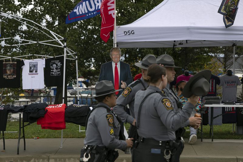 Pennsylvania State Police walk through vendors stalls before Republican presidential nominee former President Donald Trump arrives for an afternoon campaign rally at Bayfront Convention Center in Erie, Pa., Sunday, Sept. 29, 2024. (AP Photo/Rebecca Droke)