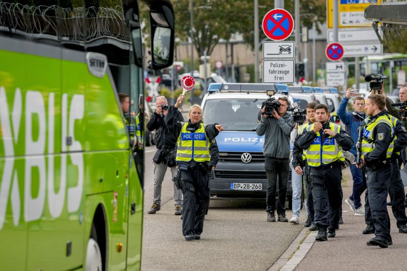 A German police officer stops a bus at the border between Germany and France, in Kehl, Germany, Monday, Sept. 16, 2024, as Germany begins carrying out checks at all its land borders. (AP Photo/Michael Probst)