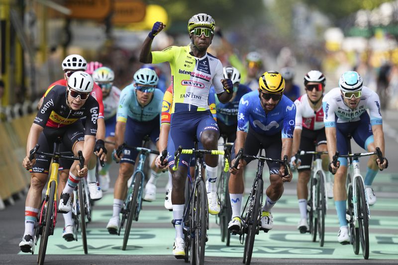 Eritrea's Biniam Girmay celebrates winning ahead of Belgium's Arnaud de Lie, left, and Colombia's Fernado Gavira, center right, during the third stage of the Tour de France cycling race over 230.8 kilometers (143.4 miles) with start in Piacenza and finish in Turin, Italy, Monday, July 1, 2024. (AP Photo/Daniel Cole)