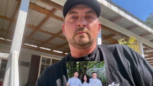 Ryan Craddock holds a photo of his three children, from left, Shawn Craddock, 18; Kendall Craddock, 17, and Cohen Craddock, 13, at his home in Hewett, W. Va., on Thursday, Aug. 29, 2024. Cohen died Saturday, Aug. 24, 2024, a day after he received a head injury while making a tackle during his middle school's football practice. (AP Photo/John Raby)