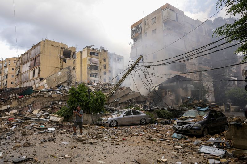 A man checks the damaged buildings at the site of an Israeli airstrike in Beirut's southern suburb, Lebanon, Tuesday, Oct. 1, 2024. (AP Photo/Hassan Ammar)