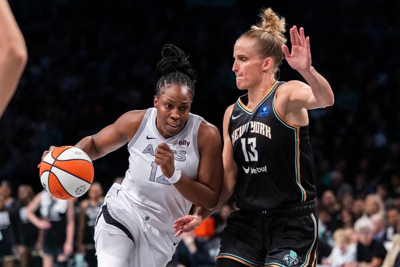 Las Vegas Aces guard Chelsea Gray (12) is defended by New York Liberty forward Leonie Fiebich (13) during the second half of a WNBA basketball second-round playoff game, Sunday, Sept. 29, 2024, in New York. (AP Photo/Corey Sipkin)