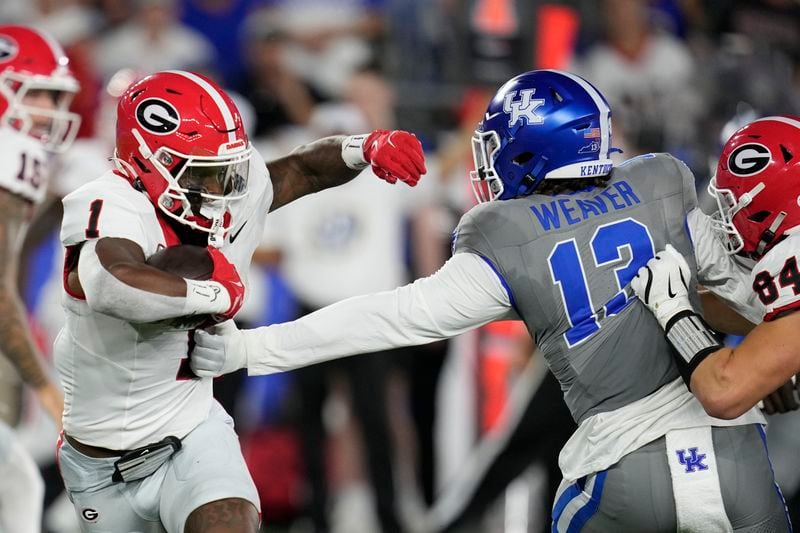 Georgia running back Trevor Etienne (1) runs past Kentucky linebacker J.J. Weaver (13) during the first half of an NCAA college football game, Saturday, Sept. 14, 2024, in Lexington, Ky. (AP Photo/Darron Cummings)